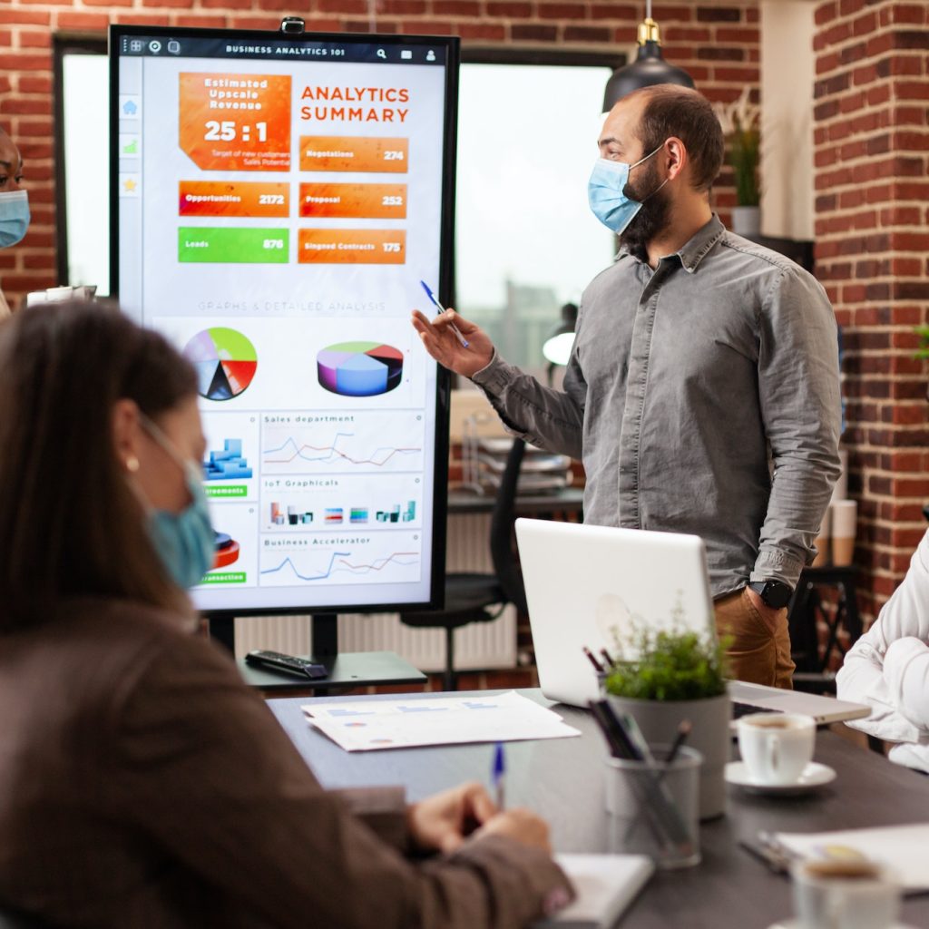 Entrepreneurs pointing at management presentation explaining